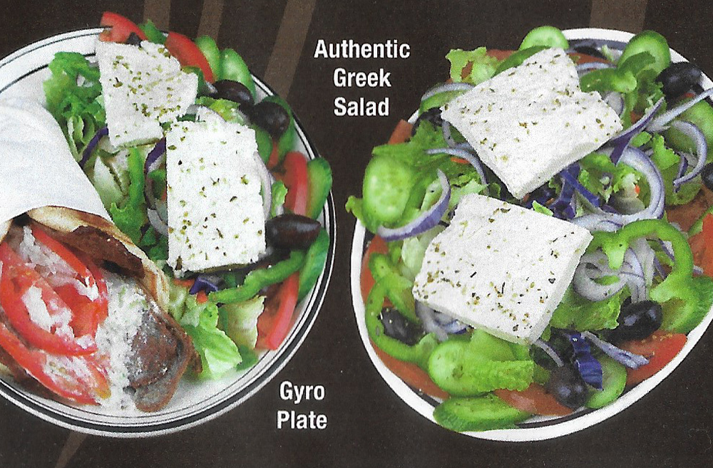 Greek salad with feta, olives, tomatoes and cucumbers over crisp greens